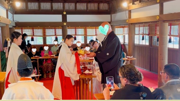 京都の神前結婚式で三々九度を行う国際カップルの新郎新婦